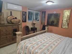 a bedroom with a bed and a dresser and windows at Exotic Paradise Guest House in Yabucoa