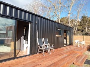 a black shipping container house with a deck at Container Stay - Taupo in Taupo
