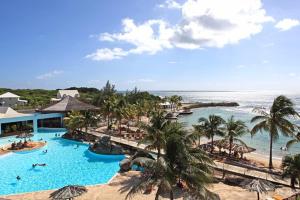 a resort with a large swimming pool next to the ocean at Studio Sucre de Canne - Résidence calme avec plage et piscine privées in Saint-François