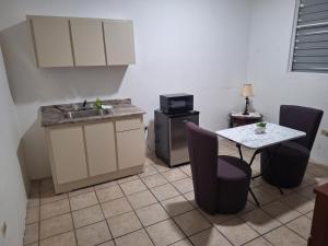 a kitchen with a sink and a table with chairs at Humacao Guest House 3 in Humacao