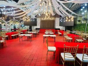 a dining room with red tables and chairs and lights at Royal Suites Condotel in Kalibo