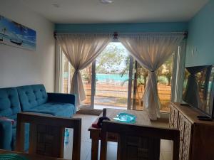 a living room with a blue couch and a large window at Apartamento Fina Dream Lagoon in Veracruz