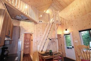 a wooden cabin with a ladder in the ceiling at Le Colvert - Waterfront Cabin with Spa in Valcartier Station