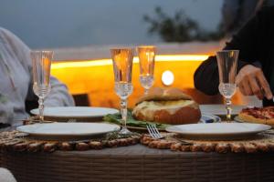 a table with plates and wine glasses and a sandwich at Granja Cafetalera Alegría in Mérida