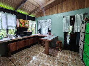 a kitchen with a counter and a table in it at Casa La Esperanza in Chachagua
