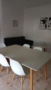 una sala de reuniones con mesa y sillas blancas en Confortable apartmento, en Bahía Blanca