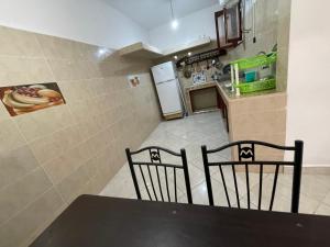 a kitchen with a table and two chairs and a refrigerator at Ocean Desert in Akhfennirr