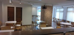 Habitación con mesas, sillas y pared de ladrillo. en バンデホテル in なんば, en Osaka