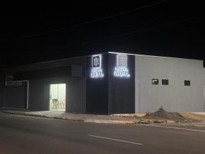 a building with neon signs on the side of it at Hotel Ideal in Inocência