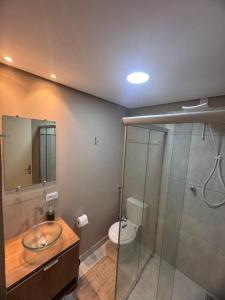 a bathroom with a sink and a toilet and a shower at Hotel Ideal in Inocência +8 photos