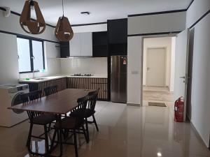 a kitchen with a wooden table and chairs in it at Seruang Cozy Stay in Teluk Panglima Garang