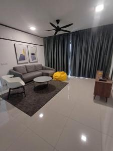 a living room with a couch and a ceiling fan at Seruang Cozy Stay in Teluk Panglima Garang