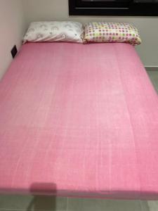 a pink bed with a pink comforter and two pillows at Habitación Grande en Apartamento Compartido in Sant Boi del Llobregat +2 photos