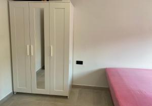 a bedroom with a white cabinet next to a bed at Habitación Grande en Apartamento Compartido in Sant Boi del Llobregat
