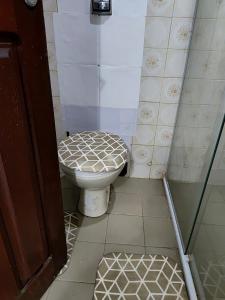 a bathroom with a toilet and a glass shower at Casa Aconchegante in Vitória da Conquista