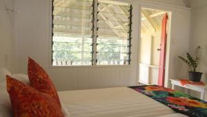 a bedroom with a bed and a window at Atiu Kia Orana Bungalows in Atiu
