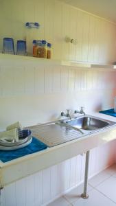 a kitchen counter with a sink and a plate at Atiu Kia Orana Bungalows in Atiu