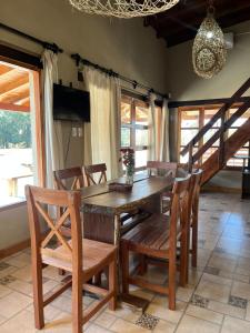 una sala da pranzo con tavolo e sedie in legno di Cabañas El Alemán 1-2 a Cerrillos