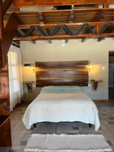 a bedroom with a large bed with a wooden headboard at Cabañas El Alemán 1-2 in Cerrillos