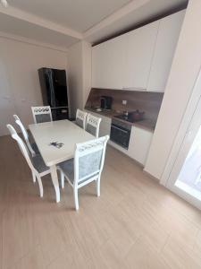 Polisi i Vogëlにあるpalmera apartamentの部屋にテーブルと椅子のあるキッチン