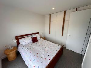Un dormitorio con una cama con lunares. en Private Getaway - Portarlington!, en Portarlington