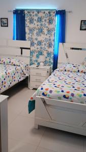 two beds in a bedroom with blue and white at Aguazul in Boca Chica