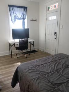 a bedroom with a bed and a desk and a computer at Guest House in McKees Rocks