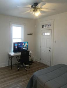 a bedroom with a bed and a desk with a computer at Guest House in McKees Rocks