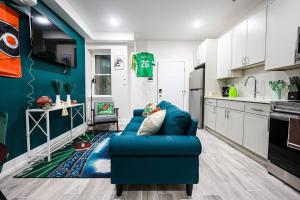 a living room with a blue couch in a kitchen at Perch in Paradise EaglesThemed Escape in Philadelphia