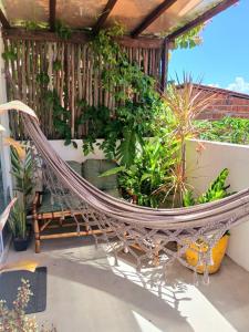 a hammock on a balcony with plants at 1 COCO BAMBÚ PIPA apto 1, a 200 m da praia e a 100 m do centro da cidade in Pipa
