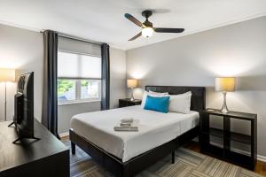 a bedroom with a bed with a ceiling fan and a tv at Brookwood Courtyard by BCA Furnished Apartments in Atlanta
