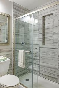 a bathroom with a glass shower with a toilet at Brookwood Courtyard by BCA Furnished Apartments in Atlanta +18 photos