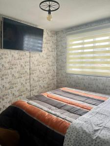 a large bed in a bedroom with a tv on the wall at Casa equipada para familias, amigos y trabajadores in Los Andes