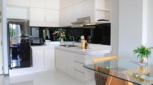 a kitchen with white cabinets and a glass table at Natural Place in Ban Khan Ham