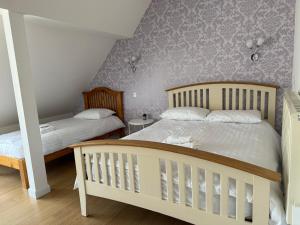 a bedroom with two beds and purple wallpaper at Sunshine three bedrooms Apartment in Insch