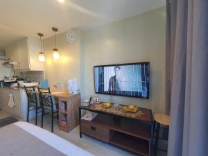 a living room with a flat screen tv on a wall at Condo near Ayala Mall Cebu & IT Park - Sea and City View with Balcony in Cebu City