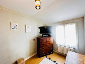a living room with a television on a dresser and a window at Maison de vacances familiale au centre de Fouras avec jardin clos - FR-1-709-100 in Fouras