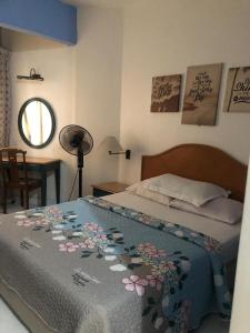 a bedroom with a bed with a blanket with flowers on it at Seri Bulan Apartment in Kampong Tanah Merah