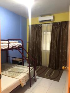 a room with two bunk beds and a window at Seri Bulan Apartment in Kampong Tanah Merah