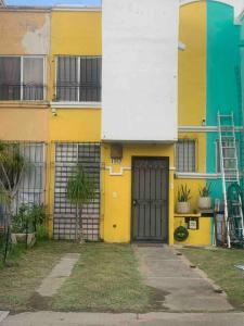 ein gelbes und weißes Gebäude mit einer Tür in der Unterkunft House near the airport in Guadalajara