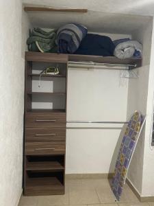 ein Schrank mit einem Holzregal und einigen Kleidungsstücken in der Unterkunft House near the airport in Guadalajara