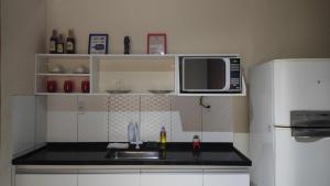 a kitchen with a sink and a microwave at Comodidades na Estrada do Coco in Camaçari