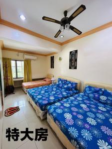 a bedroom with two beds and a ceiling fan at Hotel Langkap LW 冷甲酒店 in Kampung Degong +1 photo