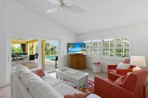 a living room with a couch and chairs and a tv at 1692 Marco Island in Marco Island