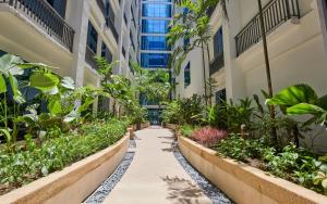 a walkway in a building with plants at Belmont Hotel Manila near NAIA Terminal 3 MNL in Manila