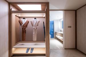 a dressing room with two racks of robes at Orange Crystal Qingdao Taidong Pedestrian Street Yan'an Third Road Hotel in Qingdao +42 photos