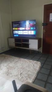 a flat screen tv sitting on a stand in a living room at 2 bedrooms 2 bathrooms shopp beach wifi in Vila Velha