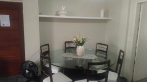 a dining room table with chairs and a vase with flowers at 2 bedrooms 2 bathrooms shopp beach wifi in Vila Velha +4 photos