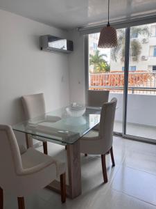 a dining room with a glass table and chairs at Apartamento Caribe Coveñas 102 in Coveñas