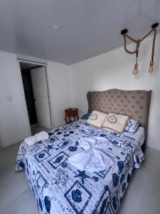 a bedroom with a bed with a blue and white quilt at Apartamento Caribe Coveñas 102 in Coveñas